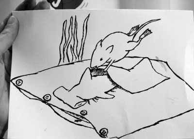 A hammerhead shark laying on a pillow and a mouse with fins covering it with a handkerchief